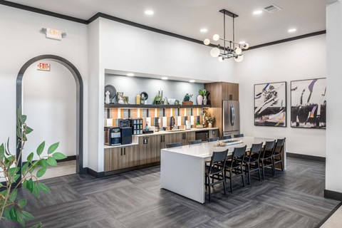A modern kitchen with a bar area and a dining table set up.