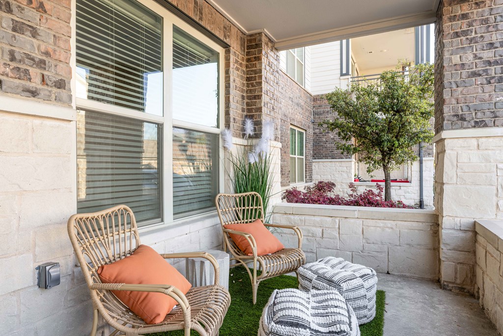 a porch with two chairs and a table and a window