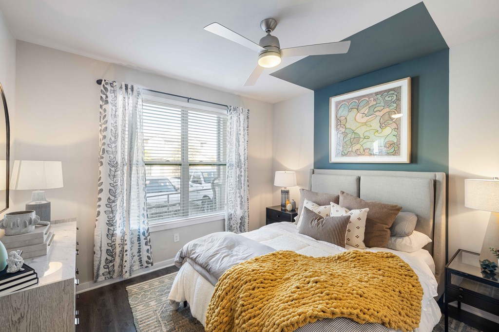 a bedroom with a large bed and a ceiling fan