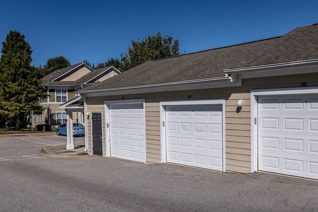 a garage with two white garage doors in front of a house