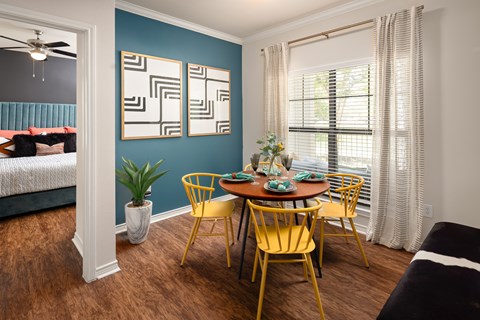 A dining room with a table set for four.