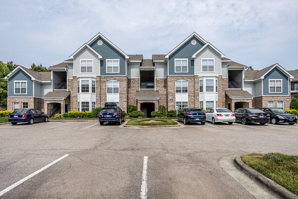 a large apartment building with a parking lot in front of it