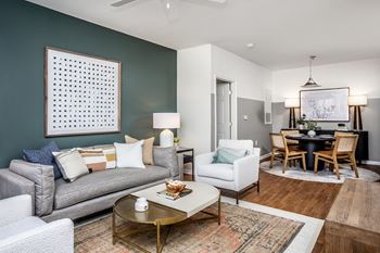 a living room and dining room with a couch and chairs and a table with a chair and