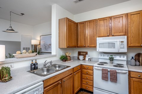 an updated kitchen with white appliances and wooden cabinets