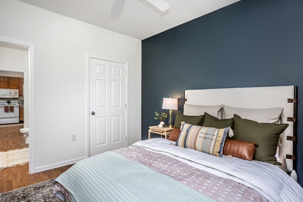 a bedroom with a bed and a nightstand with a lamp