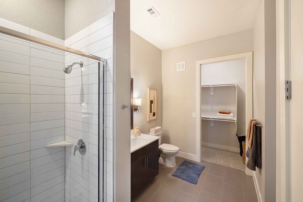 a bathroom with a shower and a toilet and a sink