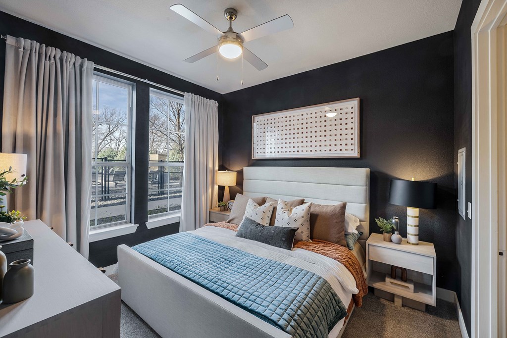 a bedroom with a large bed and a ceiling fan