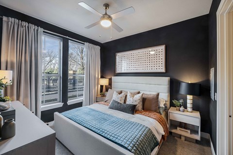 a bedroom with a large bed and a ceiling fan