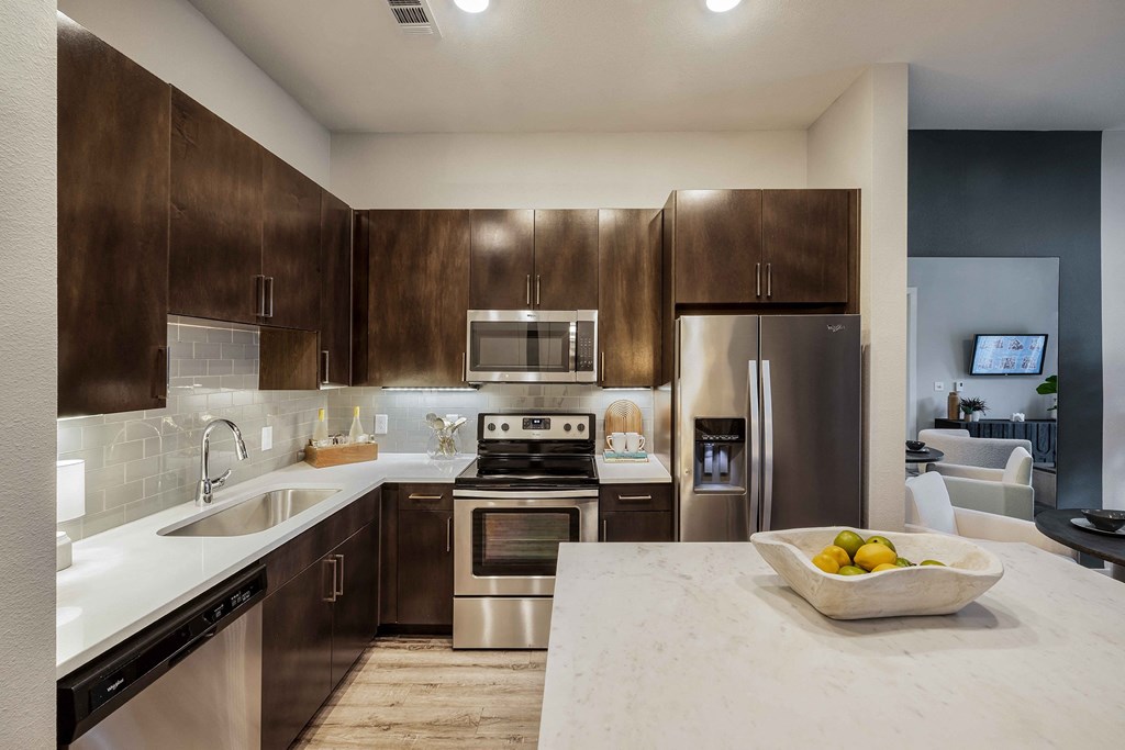 a kitchen with stainless steel appliances and marble counter tops