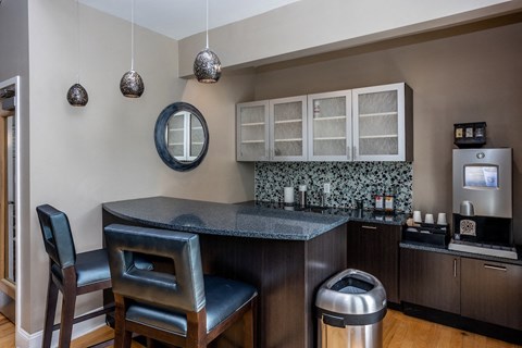 a kitchen with a bar and chairs and a sink