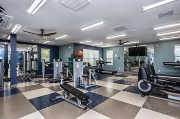 a large fitness room with weights and cardio equipment