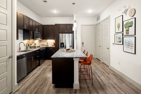 A kitchen with a table and chairs in the middle of the room.