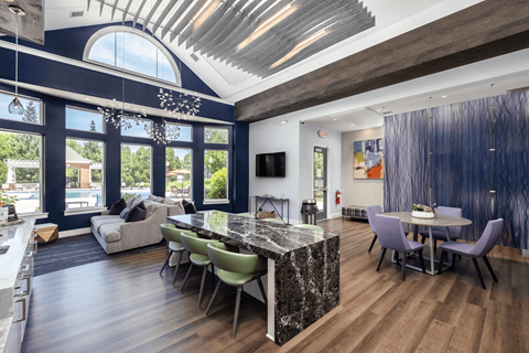 A modern kitchen with a marble island and a dining table set for four.