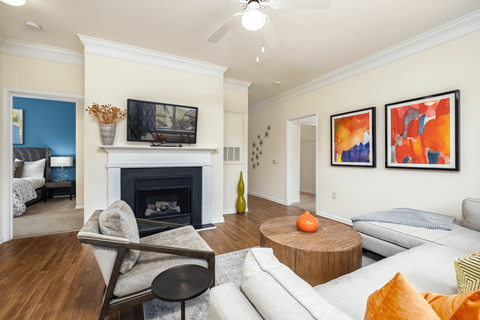 A living room with a fireplace and a television on the wall.