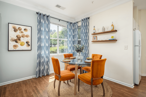 A dining room with a table and chairs.