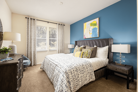 A bedroom with a large bed and a blue wall.
