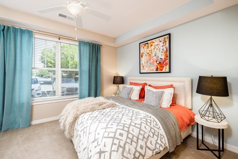 A bedroom with a large bed and a ceiling fan.