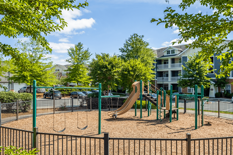 A playground with a slide, swings, and a sandbox.