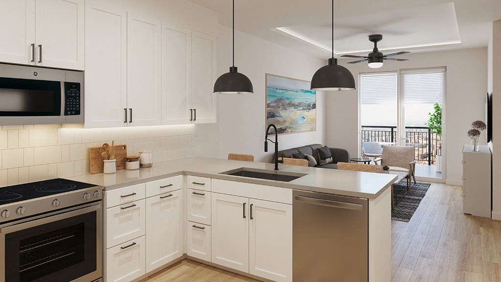 an open kitchen and living room with white cabinets and stainless steel appliances