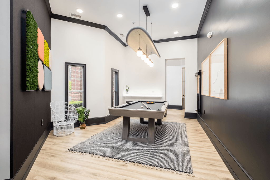 a game room with a shuffleboard table and a pool table