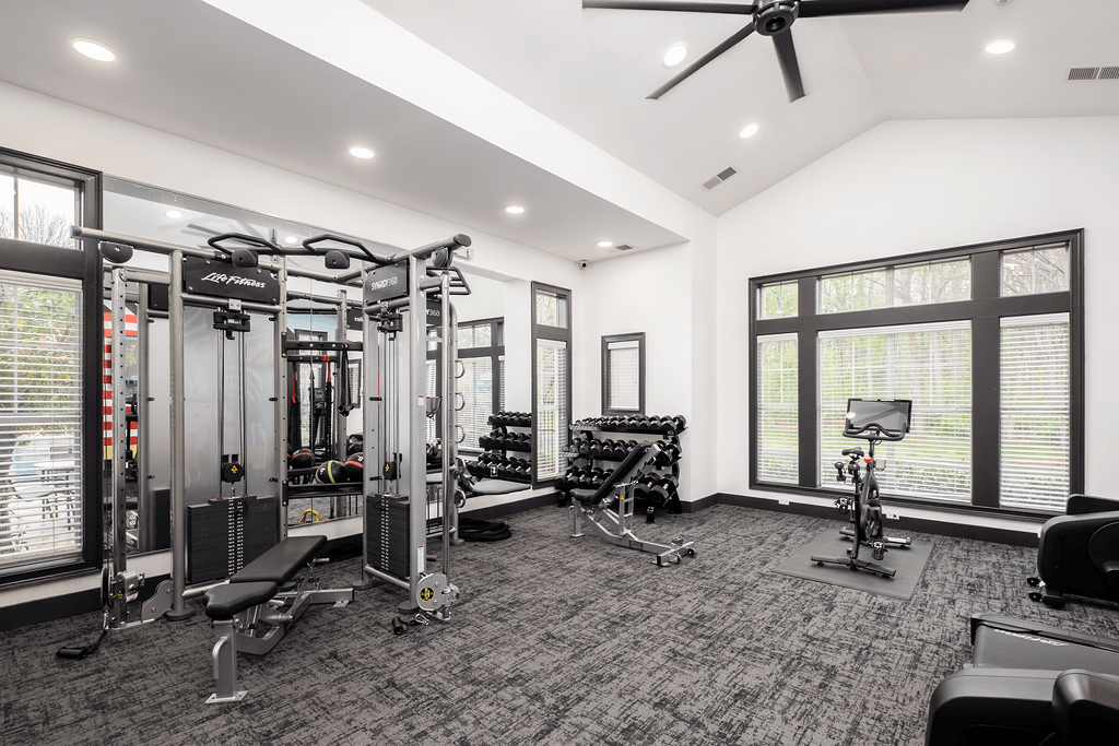 a home gym with weights and cardio equipment and large windows
