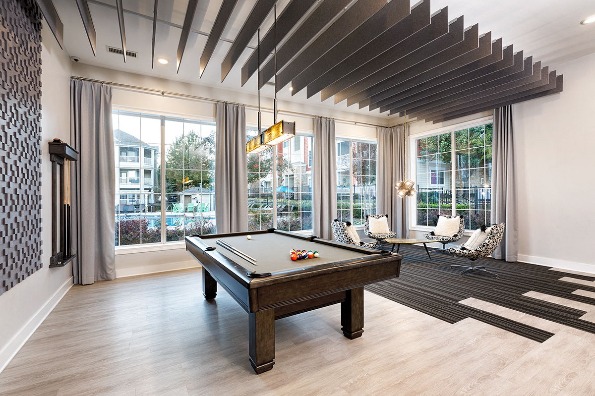 a pool table in a living room with windows