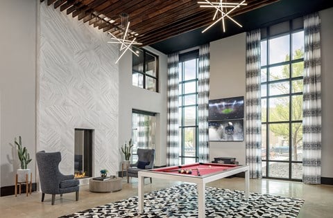 a living room with a ping pong table and a fireplace
