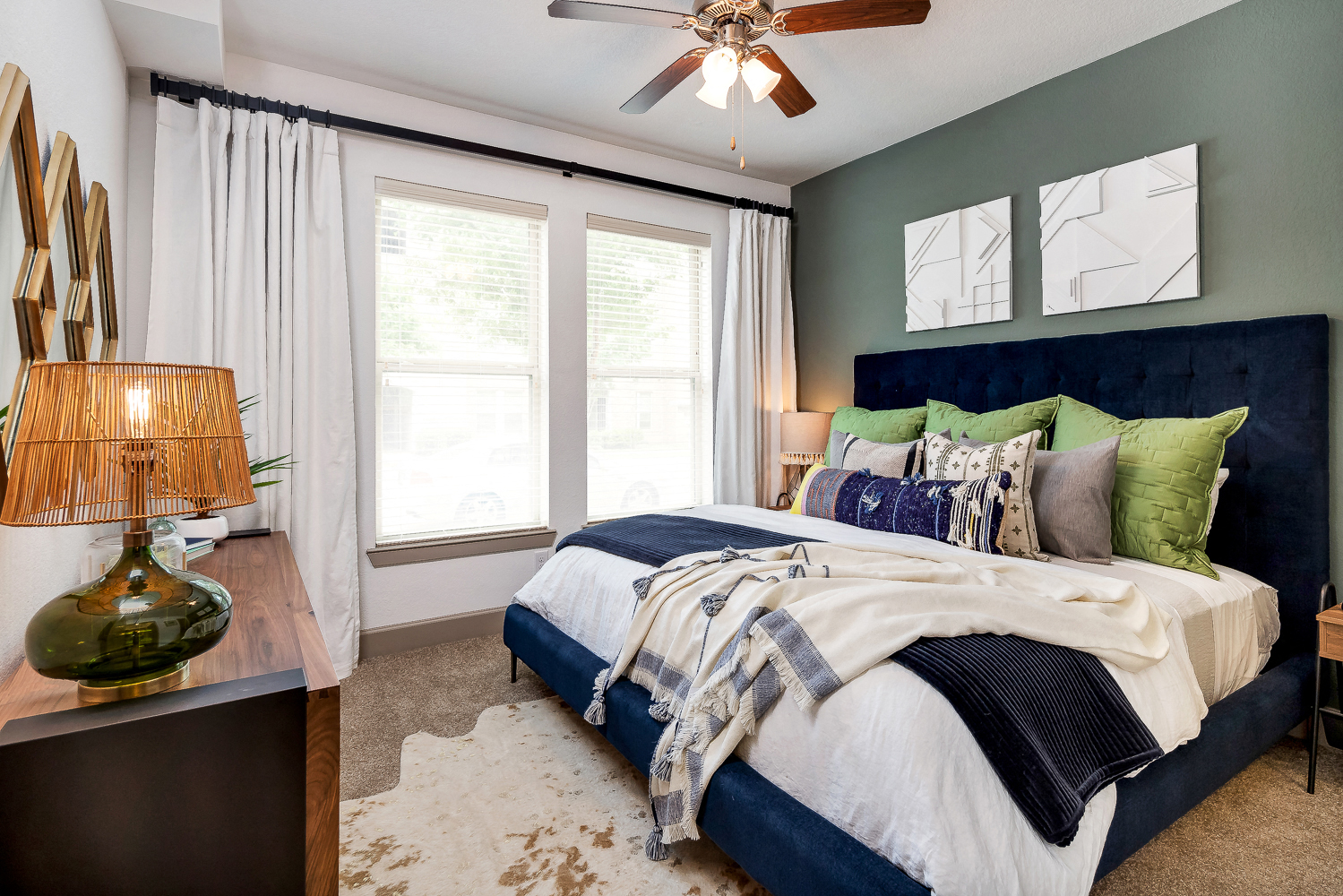 a bedroom with a large bed and a ceiling fan