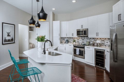 a kitchen with white cabinets and a sink and a refrigerator