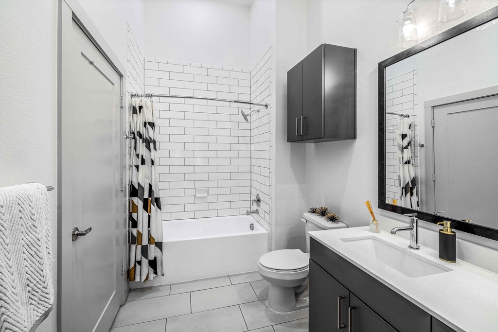 a white bathroom with a shower and a toilet and a sink