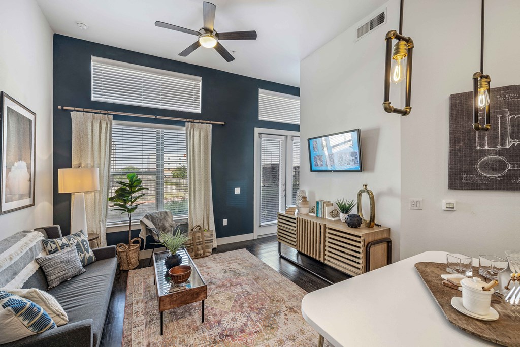a living room with blue walls and a ceiling fan