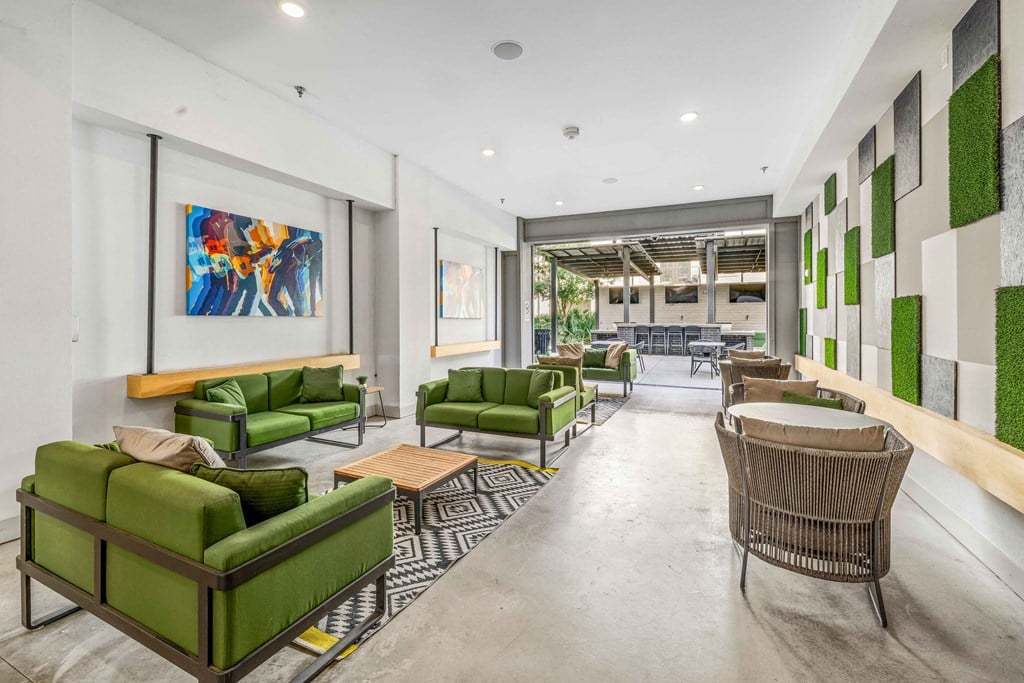 a living room with green couches and chairs and a table