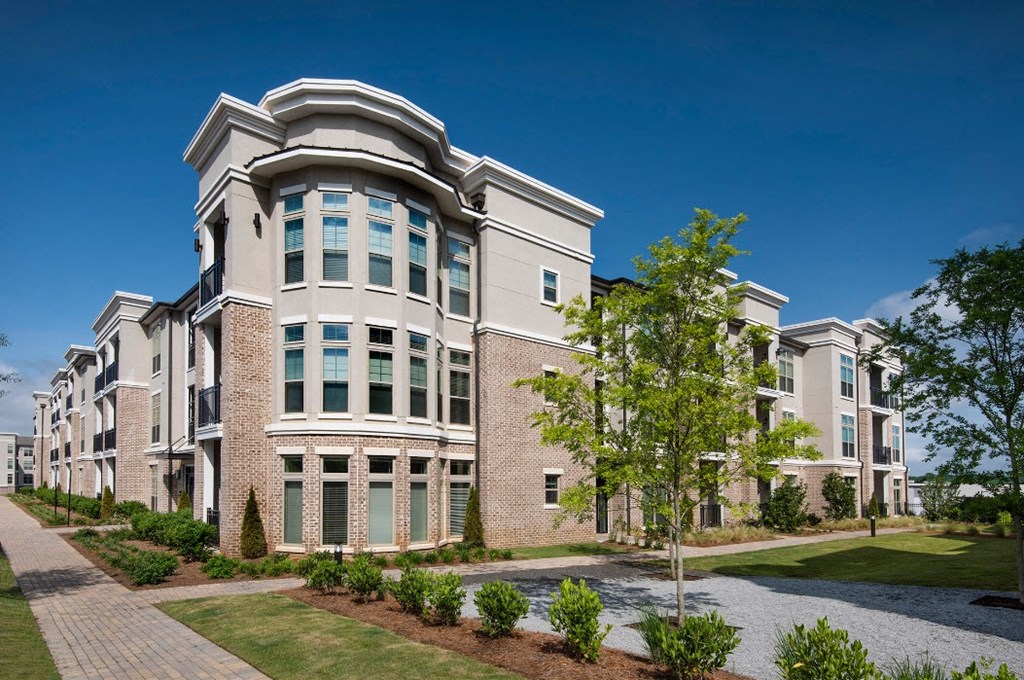 an exterior view of a building with trees and a sidewalk