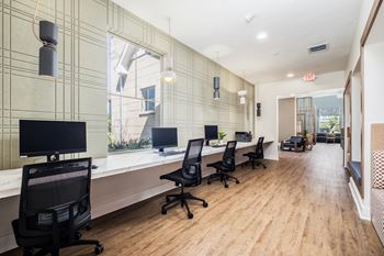 A modern office with wood floors and black chairs.