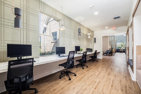 A modern office with wood floors and black chairs.