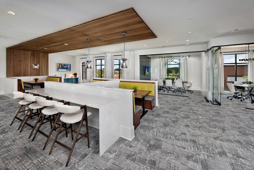 a large kitchen and dining area with a white counter and chairs