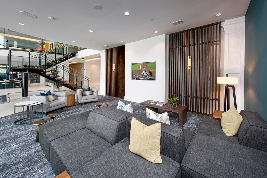 a living room with a gray couch and a staircase