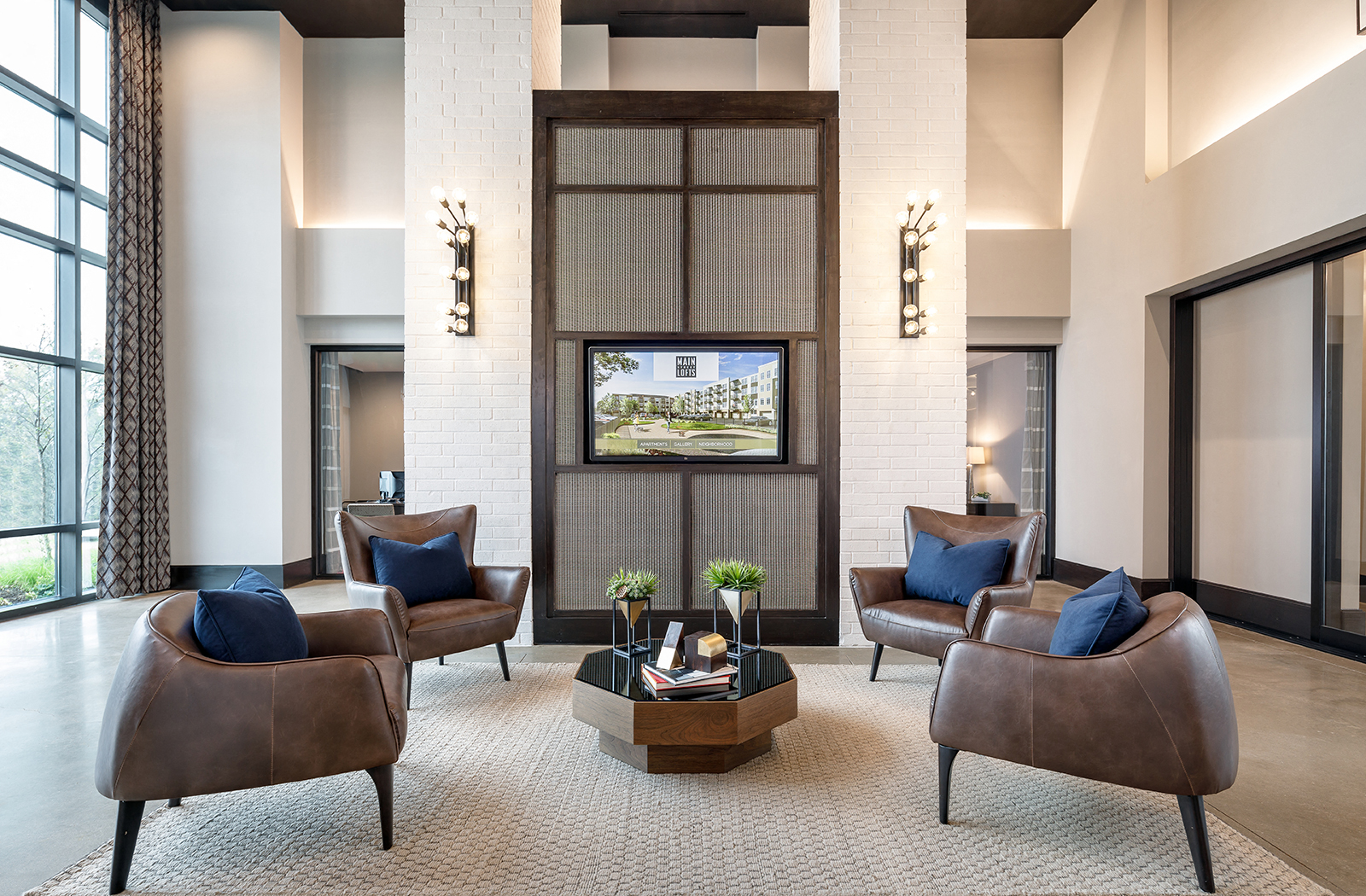 a lobby of a hotel with chairs and a television