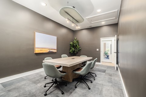 A conference room with a long table and chairs.