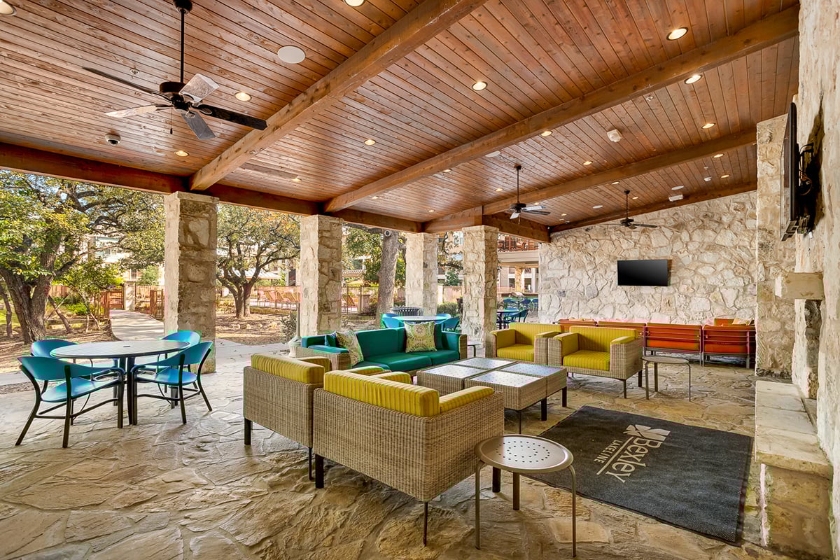 a covered patio with furniture and a tv