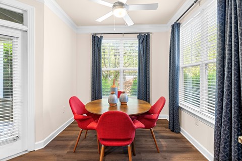 A dining room with a table and chairs.
