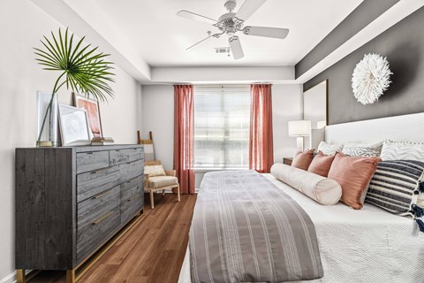 A bedroom with a large bed and a ceiling fan.