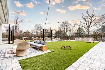 a backyard with a sod lawn and a fire pit