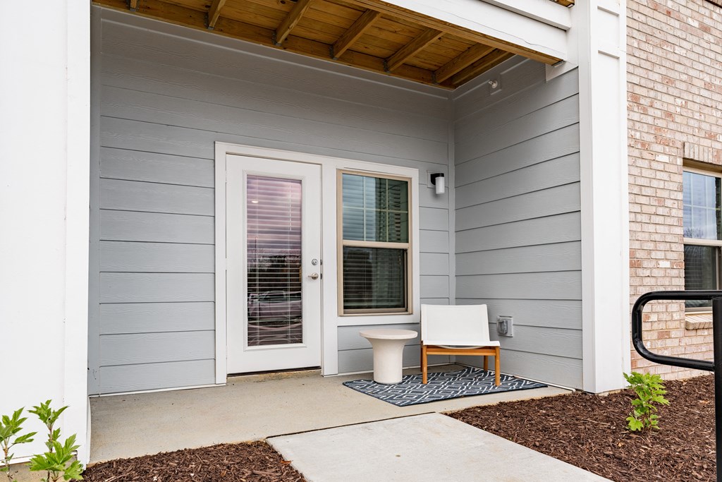 a white chair sits on a blue rug in front of a white door