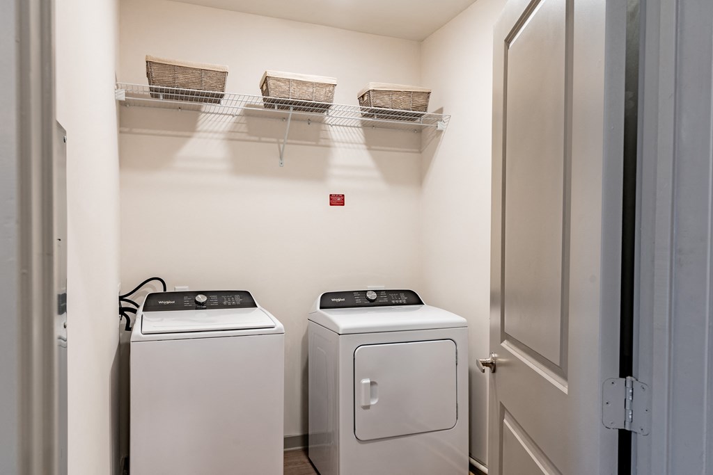 a laundry room with two washers and a dryer