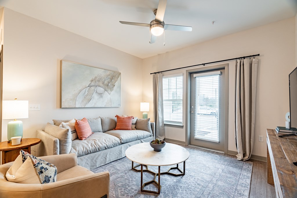 a living room with a couch coffee table and sliding glass doors