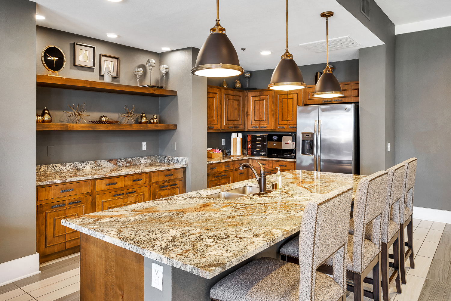 a kitchen with granite counter tops and a long island with chairs