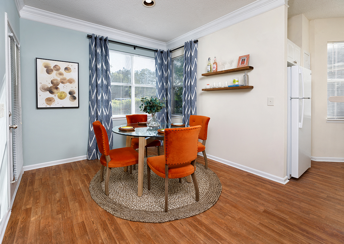 a dining room with a table and chairs and a refrigerator