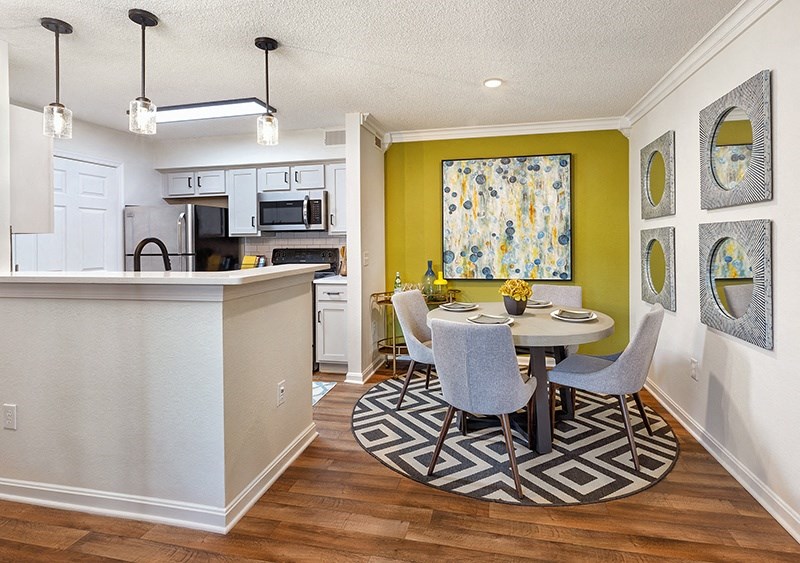 A kitchen with a dining table and chairs in the middle of the room.