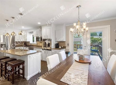 A modern kitchen with a dining table and chairs.
